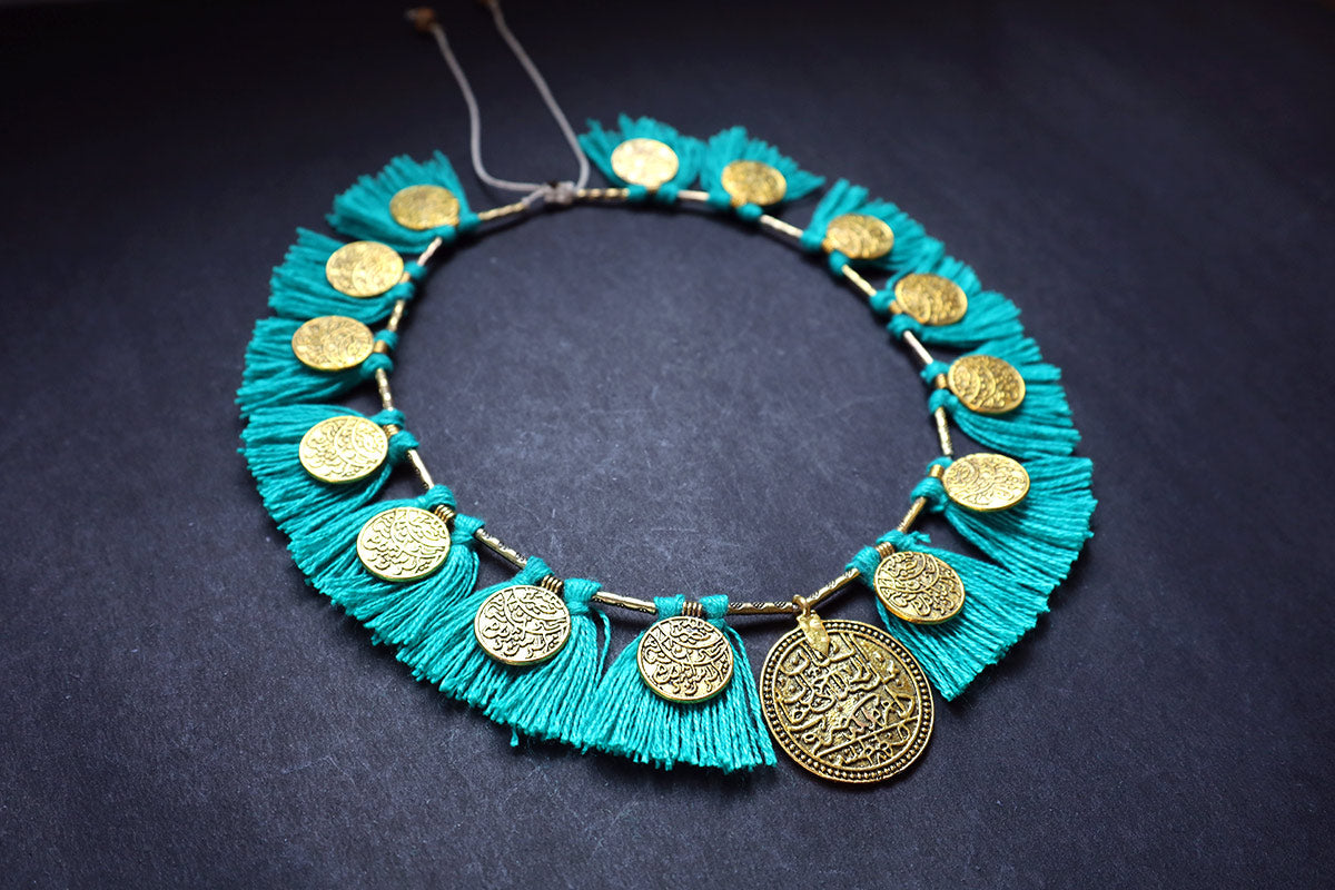 Perspective view of short ginni and tassel cyan colored necklace – fashion jewellery for women