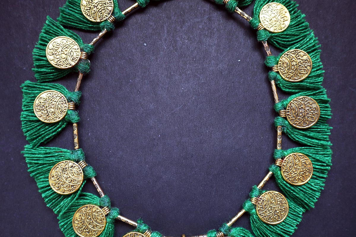 Close-up of middle portion of ginni and tassel moss green colored necklace – fashion jewellery for women
