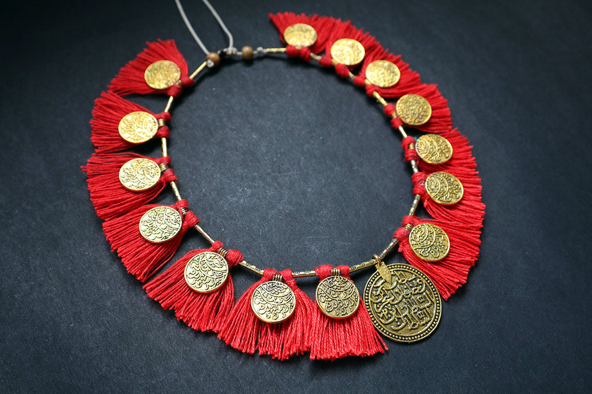 Perspective view of short ginni and tassel tomato red colored necklace – fashion jewellery for women