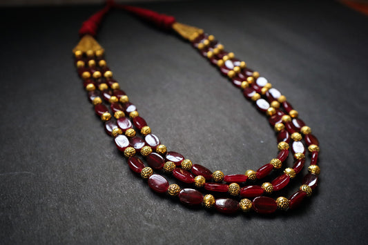 Perspective view of 3 layered golden balls & oval glass beaded necklace on a dark background – women fashion jewellery
