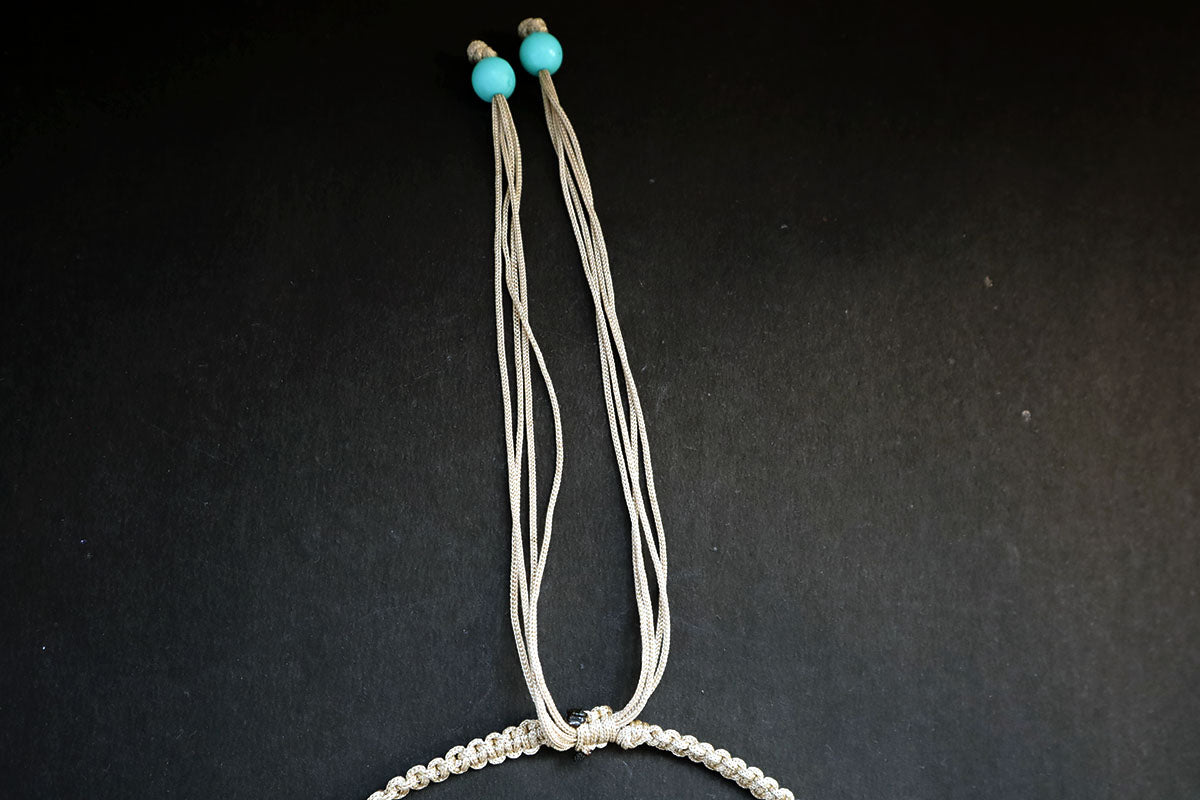 Showing the knot structure of the hemp weaved short necklace with plastic beads and cowrie – fashion jewellery for women