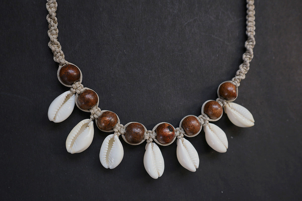 Bottom section close-up of hemp weaved short necklace with wooden beads and cowrie – fashion jewellery for women