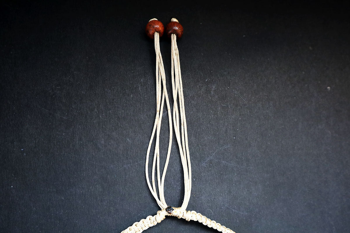 Showing the knot structure of hemp weaved short necklace with wooden beads and cowrie – fashion jewellery for women