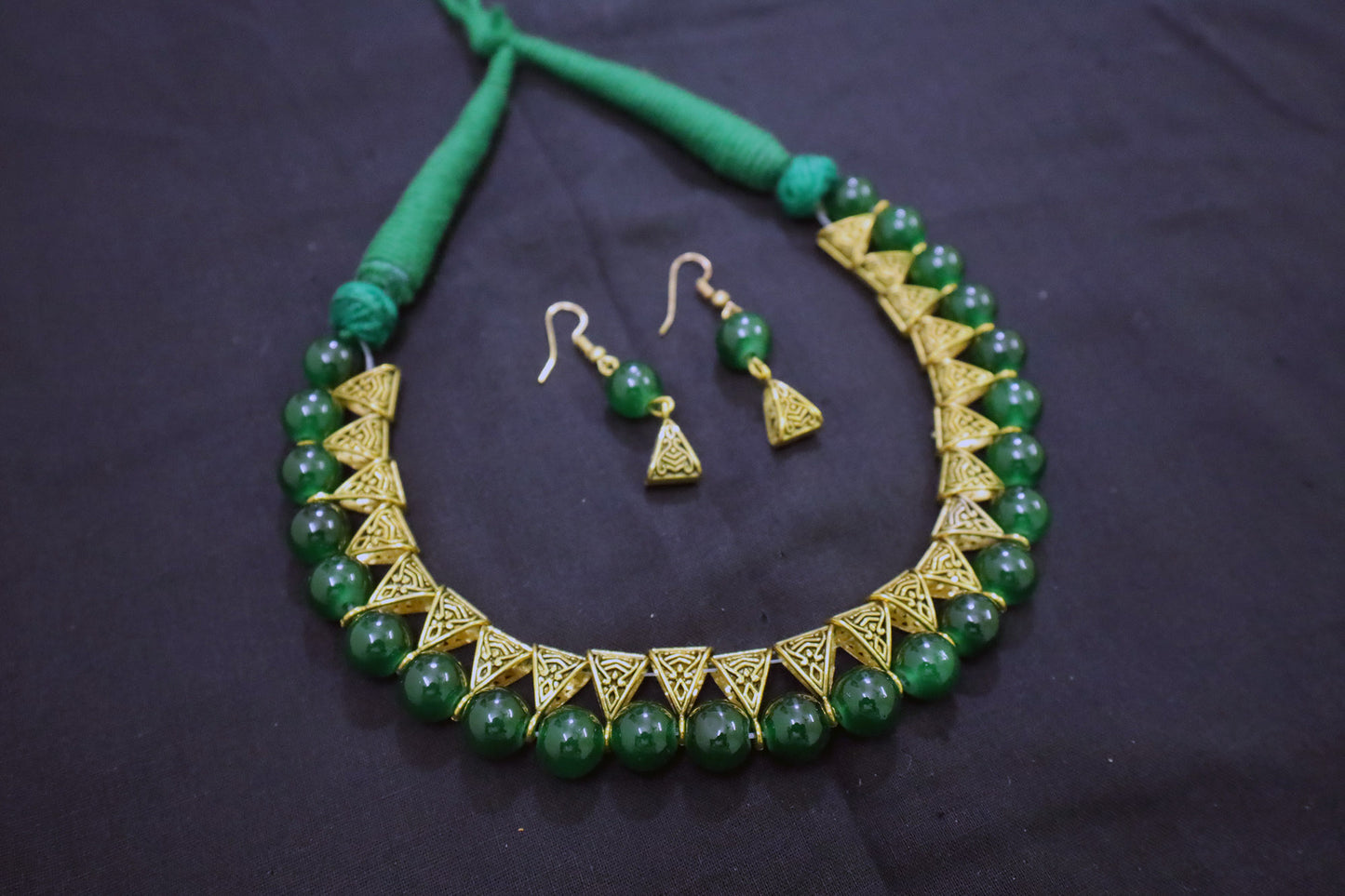 Angle view of green glass beads golden loop necklace and earrings set