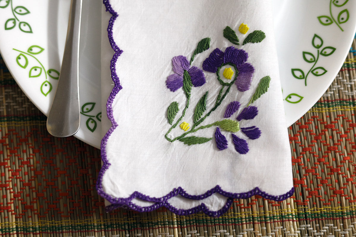 Close-up of Violet Hand Embroidery Napkins folded, highlighting intricate violet and green embroidery on cotton