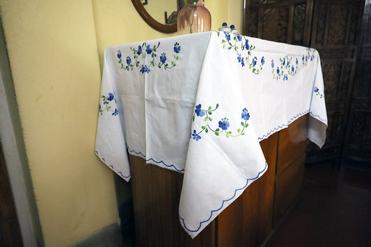 Side angle shot of Blue Hand Embroidery Table Cloth showcasing handcrafted designs with a chest of drawers.
