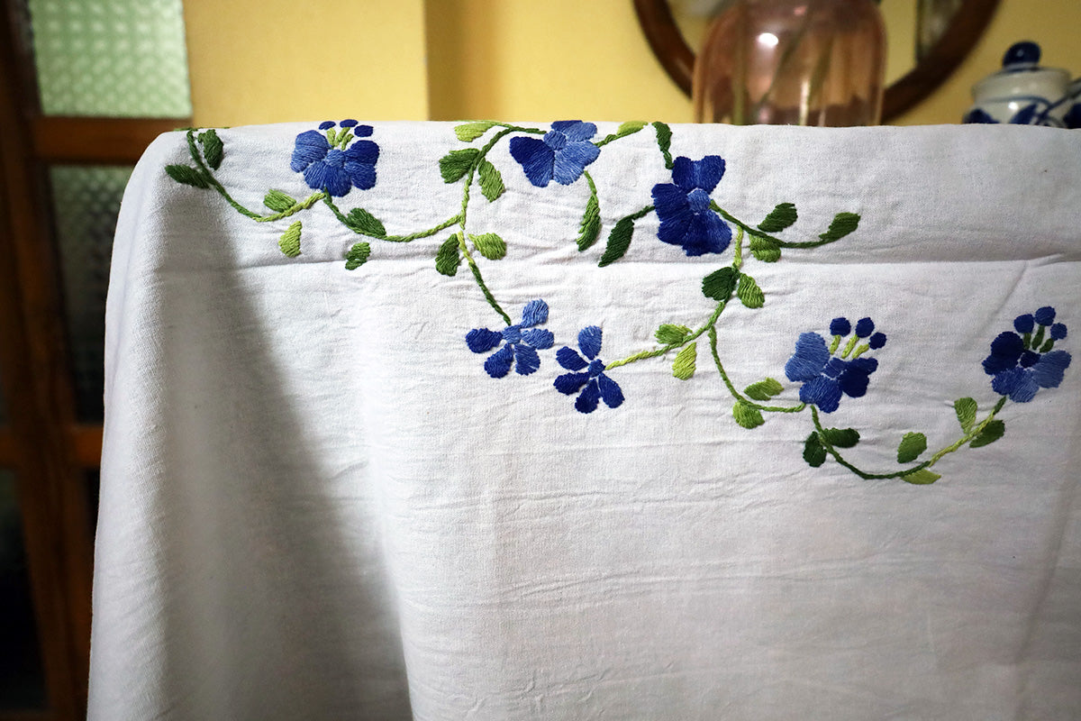 Close-up of Blue Hand Embroidery Table Cloth’s intricate embroidery and smooth texture beside a chest of drawers.