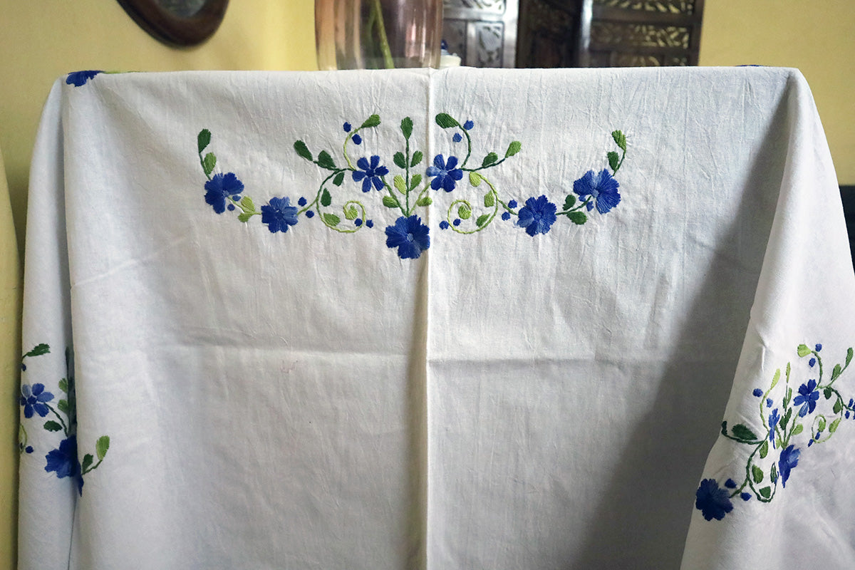 Side angle of Navy Blue Hand Embroidery Table Cloth highlighting handcrafted embroidery beside a chest of drawers.