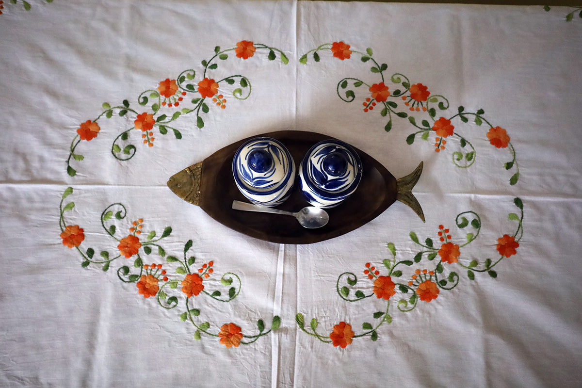 Top view of Orange Hand Embroidery Table Cloth draped on a chest of drawers, displaying its intricate surface patterns.