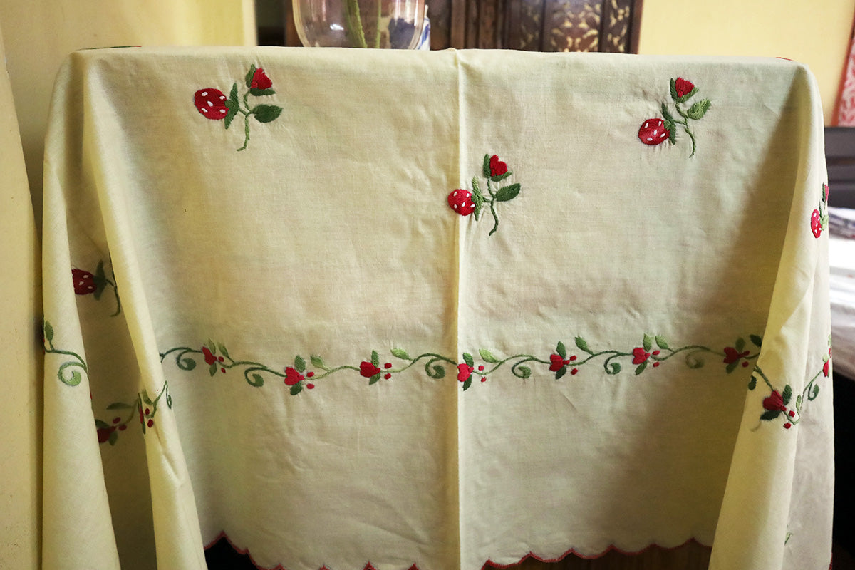 Close-up of Wine Red Hand Embroidery Table Cloth’s detailed embroidery patterns beside a chest of drawers.