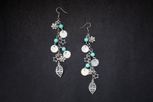 Top view of pearl and oxidized long chain earrings with big leaf, flower, and star charms