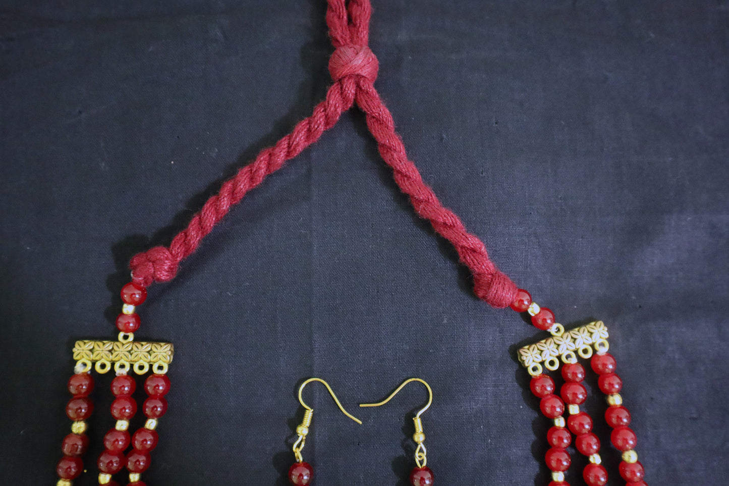 Top tassel close-up of 3 layered glass beads and golden ginni necklace set with earrings