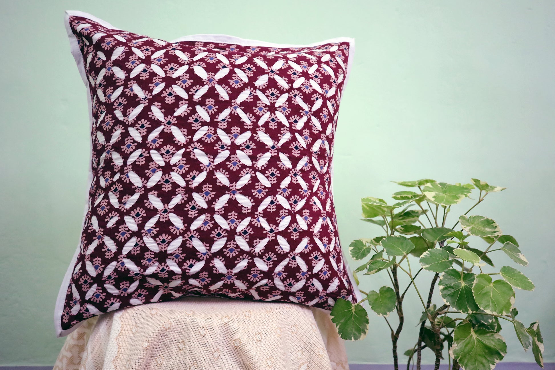 A beautiful display of a Maroon Cutwork Ajrakh Print Cushion Cover