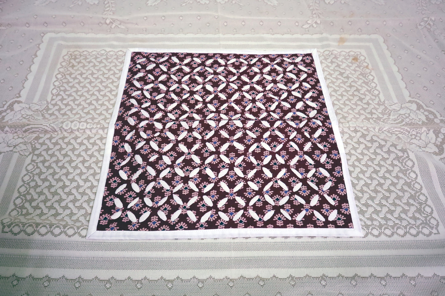 A beautiful display of a Maroon Cutwork Ajrakh Print Cushion Cover