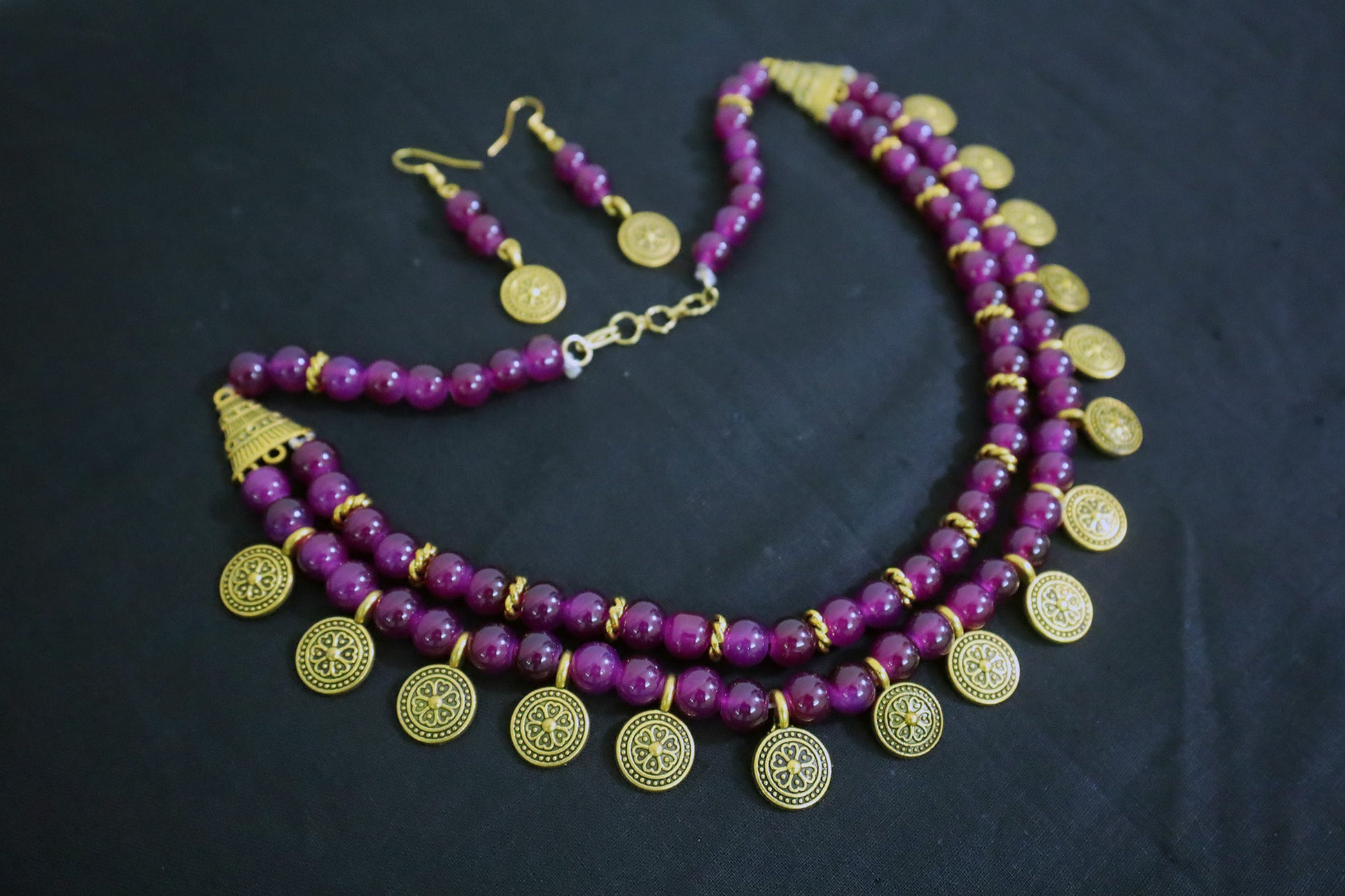 Angle view of amethyst 2 layered glass beads and golden ginni necklace set