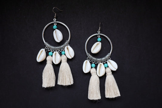 Top view of handcrafted pair of cowrie seashell and tussle oxidized hoop dangle earrings