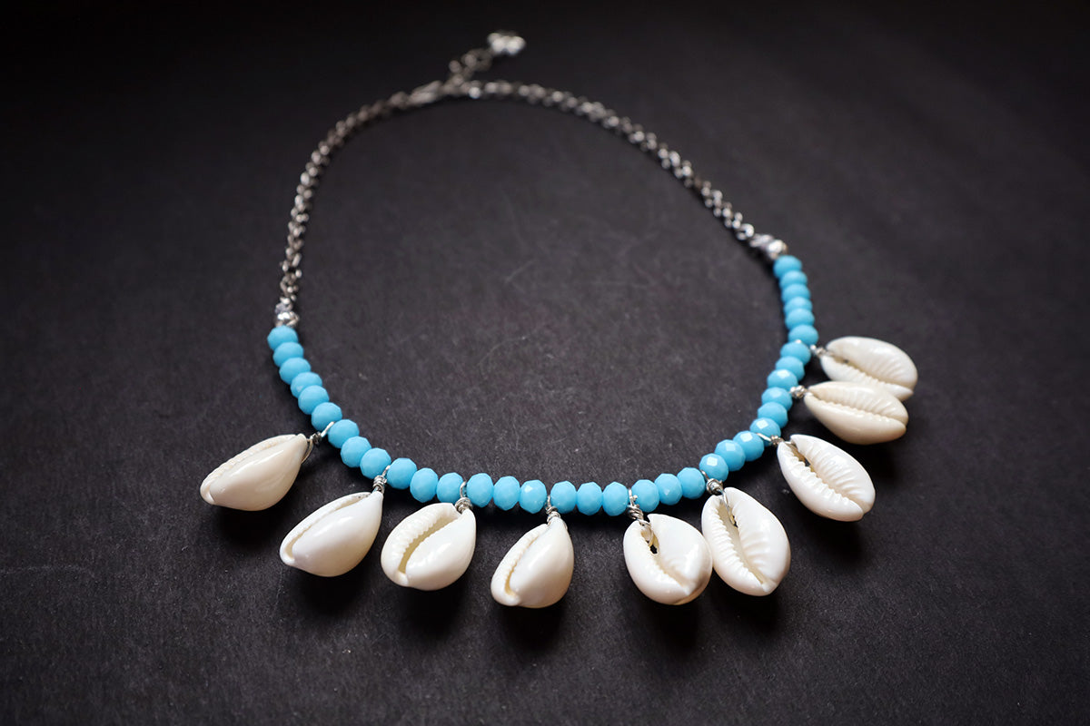 Perspective view of turquoise crystal beads & cowrie short necklace on a dark background – women fashion jewellery