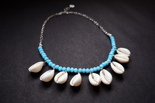 Perspective view of turquoise crystal beads & cowrie short necklace on a dark background – women fashion jewellery