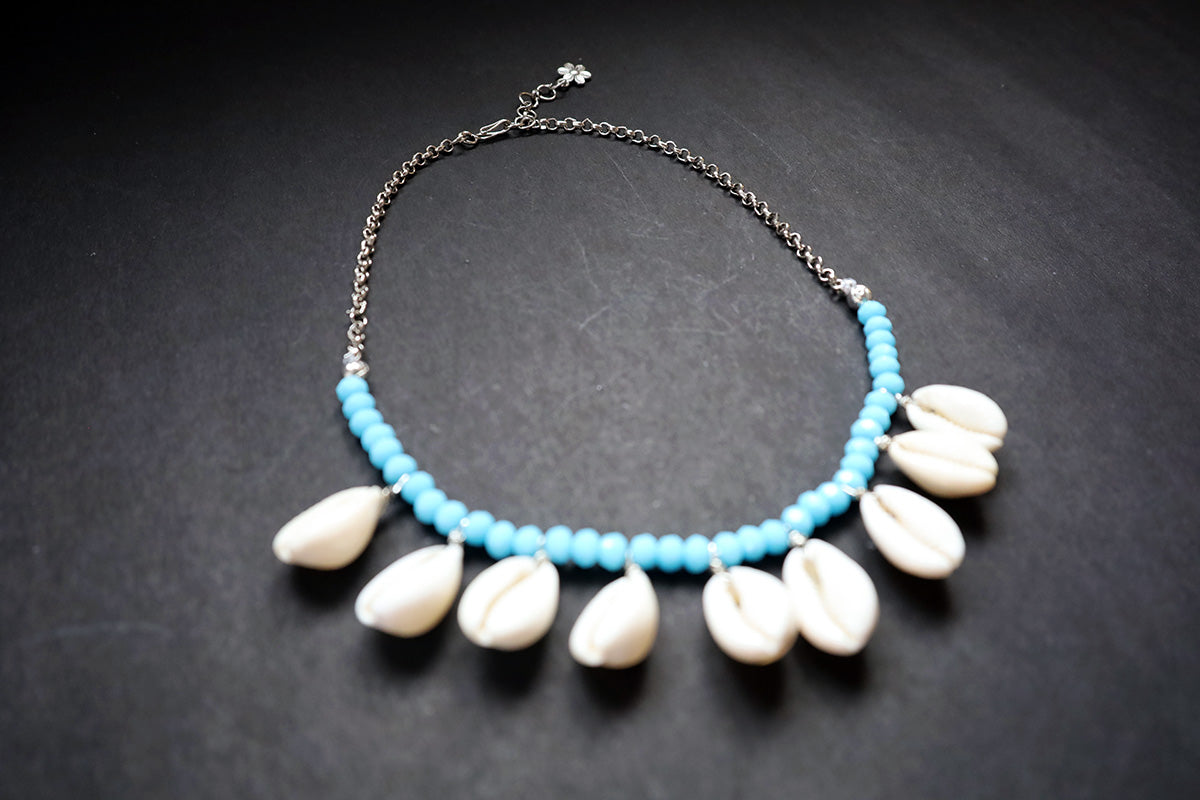 Showing full chain and hook of turquoise crystal beads & cowrie short necklace on a dark background – artificial jewellery