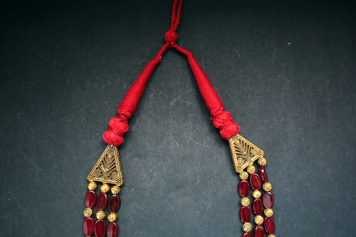 Showing tassel structure of 3 layered golden balls & oval glass beaded necklace on a dark background – artificial jewellery