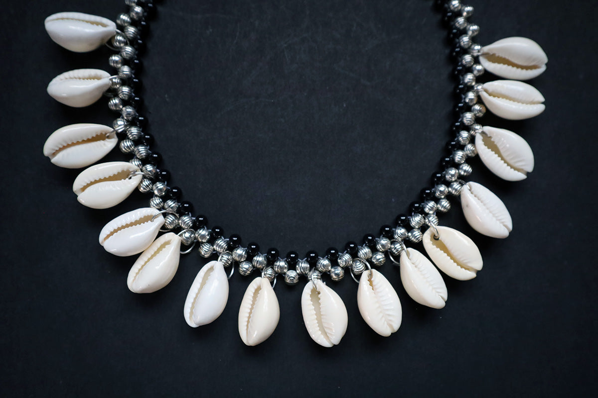 Bottom section close-up of metal beads and cowrie short silver colored necklace – fashion jewellery for women