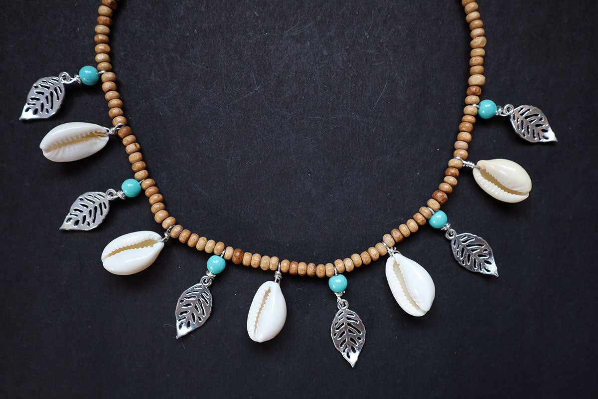 Bottom section close-up of wooden beads short necklace with cowrie, oxidized leaf charms – fashion jewellery for women