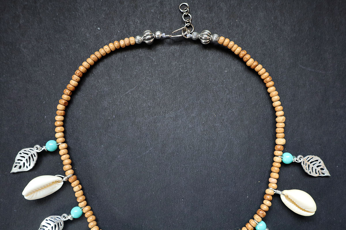 Showing the knot structure of the wooden beads short necklace with cowrie, oxidized leaf charms – fashion jewellery for women