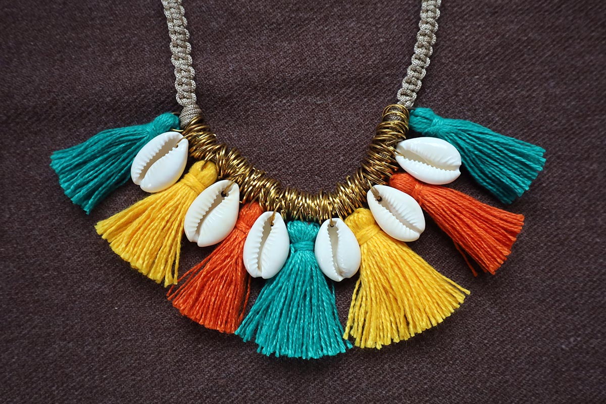 Bottom section close-up of tassel and cowrie multicolored necklace – fashion jewellery for women