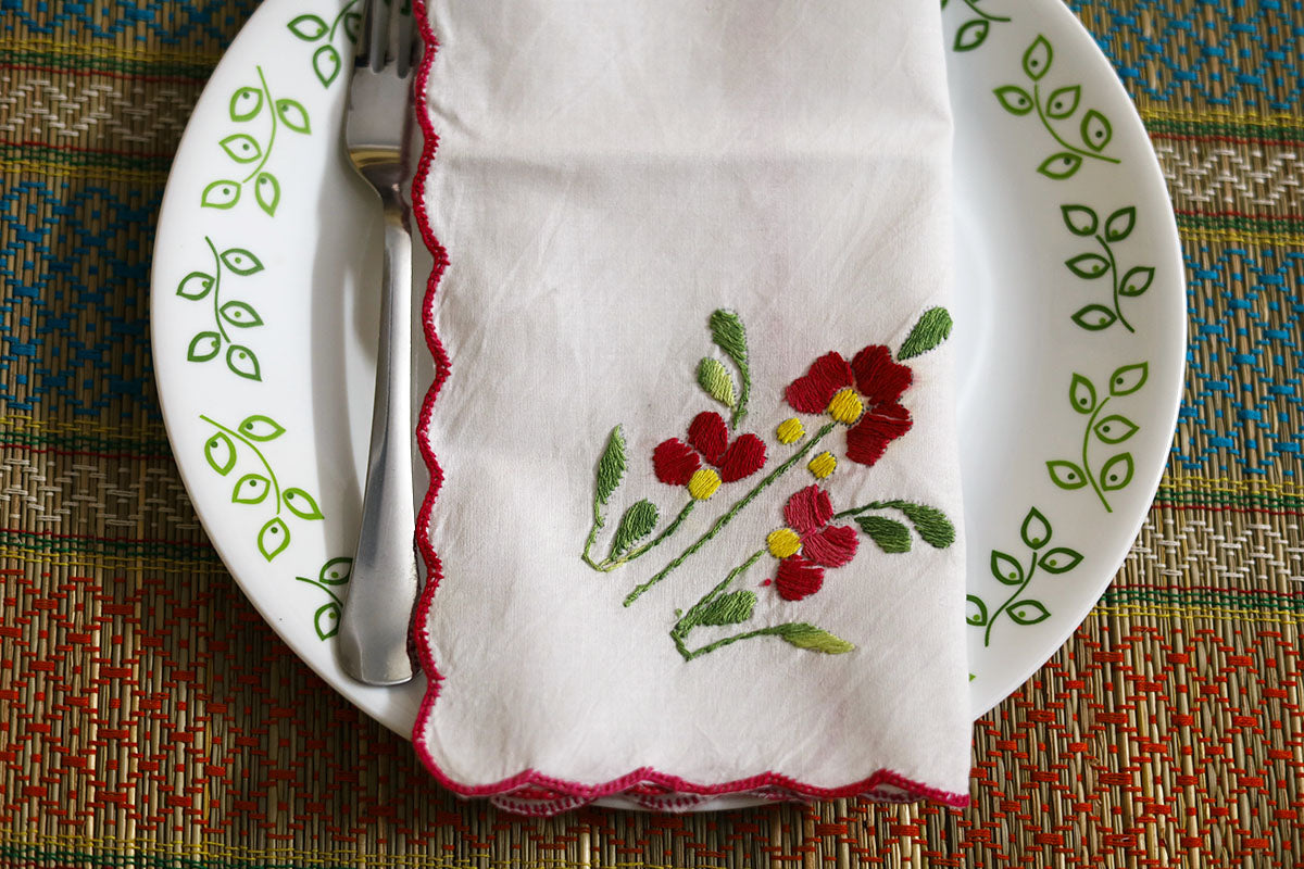 Close-up of Crimson Red Hand Embroidery Napkins folded, with detailed crimson embroidery and green accents