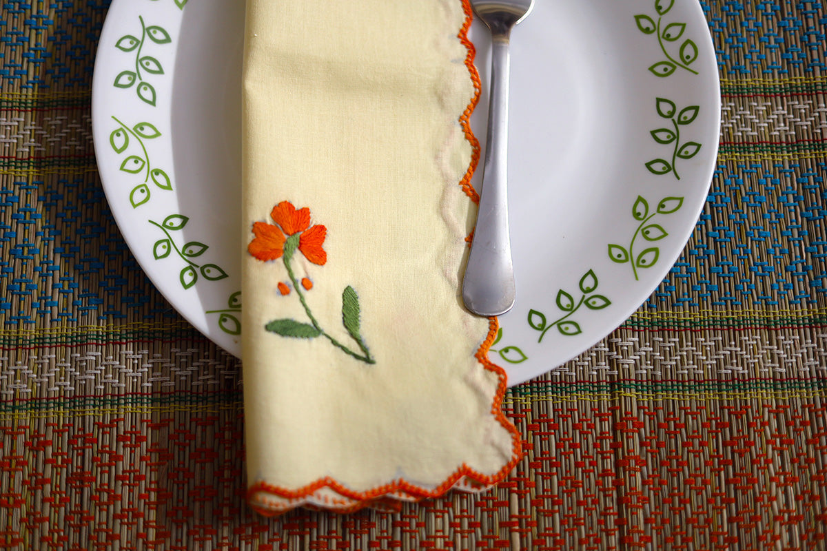 Close-up of folded Orange Hand Embroidery Napkins with intricate orange floral embroidery on soft cotton