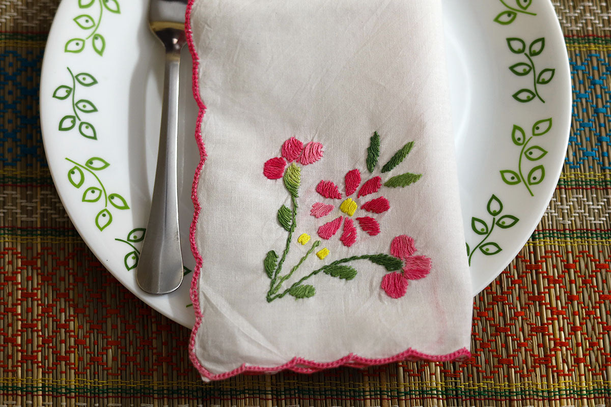 Close-up view of folded Pink Hand Embroidery Napkins, showcasing intricate pink and green embroidery details