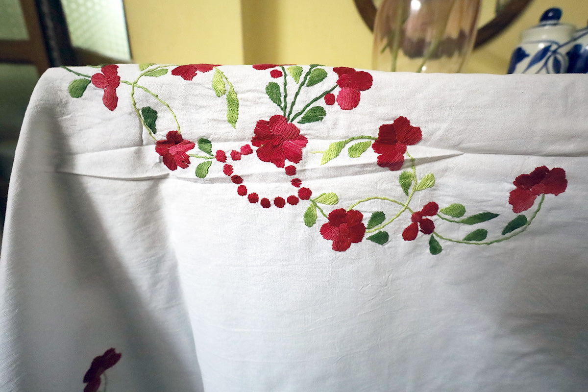 Close-up of Maroon Hand Embroidery Table Cloth’s intricate patterns paired with a chest of drawers.