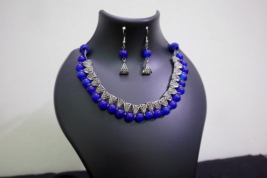 Closer view of navy blue glass beads silver loop necklace set on black mannequin