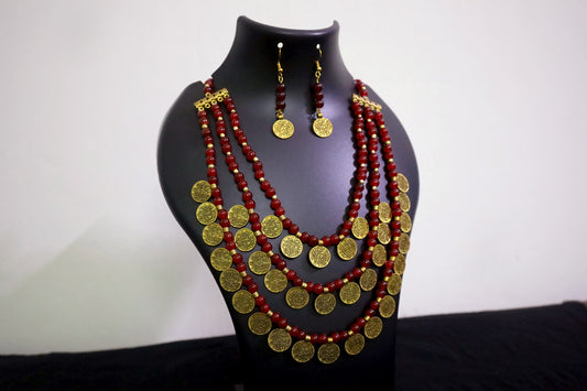Closer view of 3 layered glass beads and golden ginni necklace with earrings on black jewellery mannequin