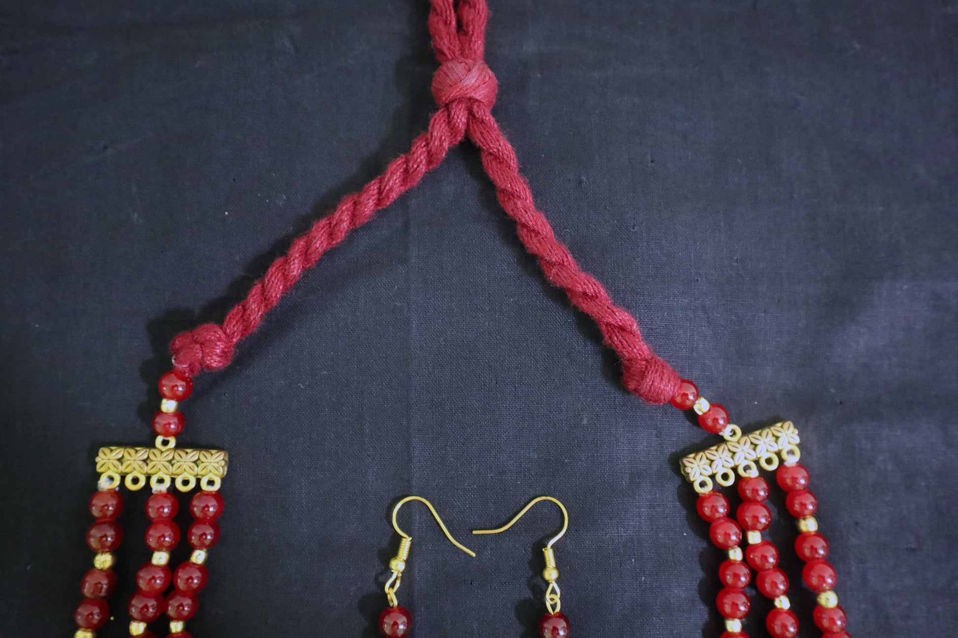 Top tassel close-up of 3 layered glass beads and golden ginni necklace set with earrings